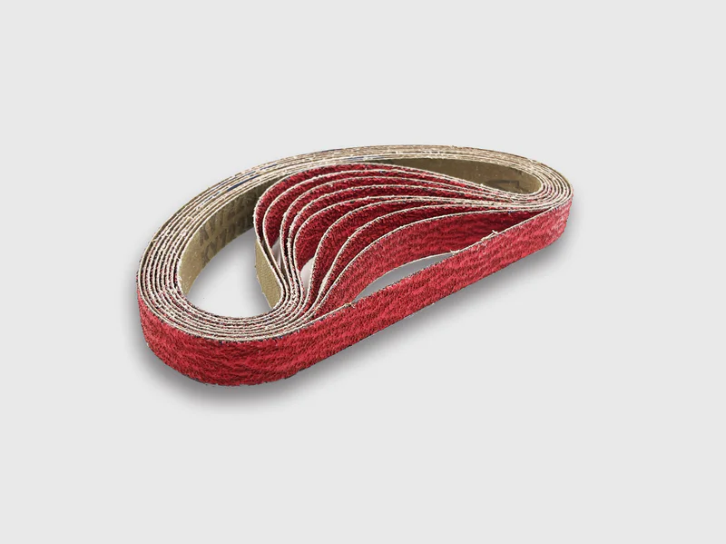 Red ceramic abrasive sanding belts coiled together, industrial grade, cloth backing, white background product image