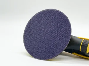Purple ceramic net mesh sanding disc, zirconia alumina abrasive, attached to power tool in workshop setting