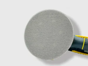 Gray mesh net sanding disc with aluminum oxide grain attached to power sander in workshop setting