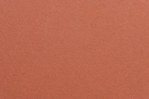 Close-up of red ceramic sanding disc surface, showing abrasive grain and durable backing for professional use