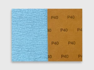 Detail view of blue zirconia alumina sanding disc with P40 grit and brown cloth backing on white background