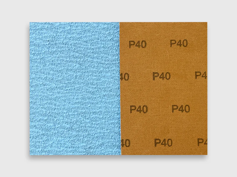 Detail view of blue zirconia alumina sanding disc with P40 grit and brown cloth backing on white background